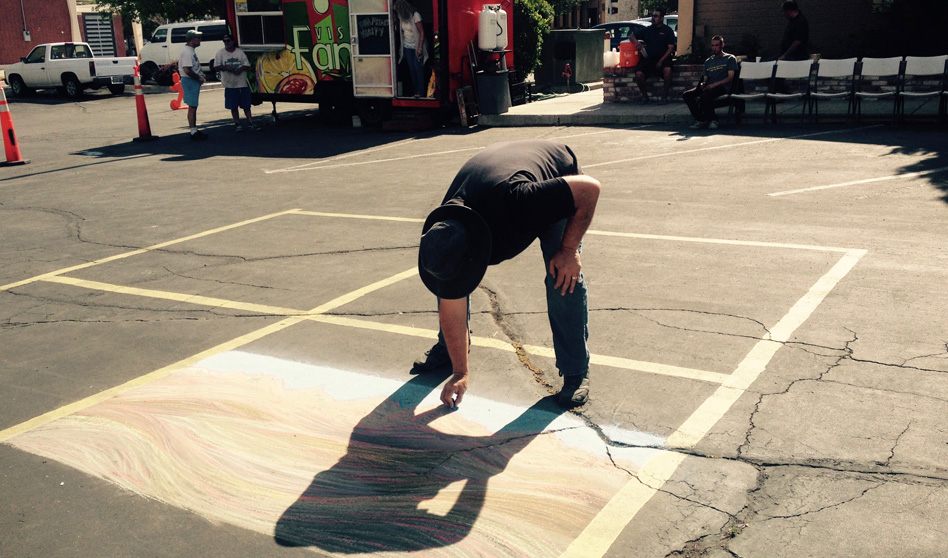 Dominic Martinelli drawing with chalk in a parking lot